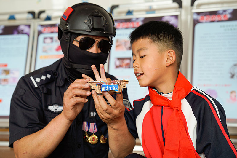 孩子向緝毒警解說(shuō)”獵毒偵察機“楚雄州公安局供圖