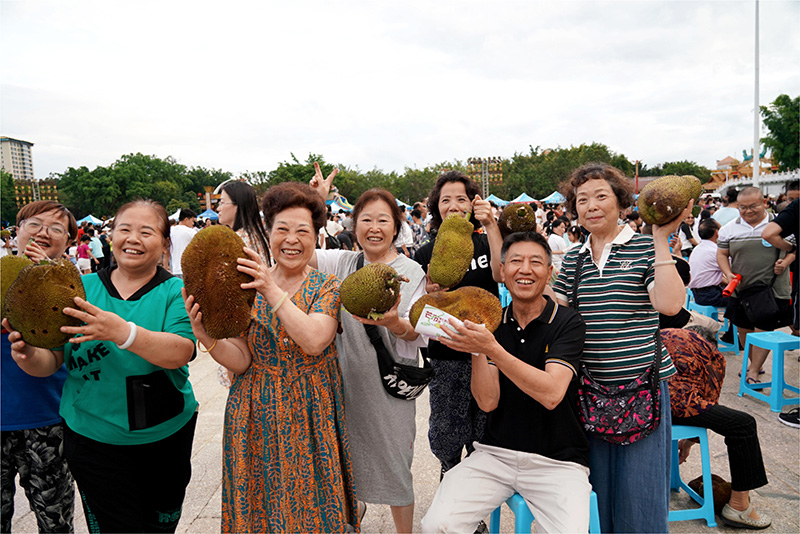 【2】芒市水果分享現(xiàn)場(chǎng)市民、游客與領(lǐng)取到的水果合影留念。楊幫慶-攝